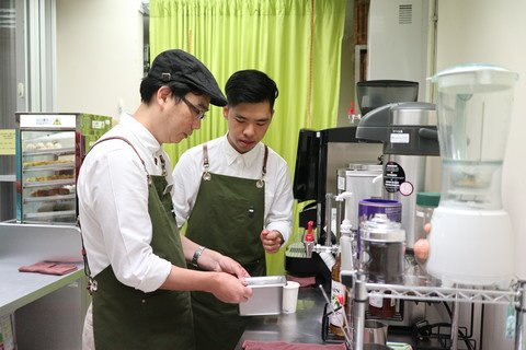 起初製作咖啡時，梁Sir（右）都會先示範，再鼓勵學員嘗試，現時阿新（左）已可獨力完成。 