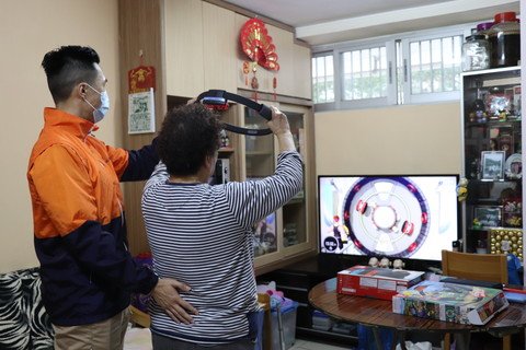 物理治療師與曾婆婆使用遊戲機做運動。(Chinese Only)