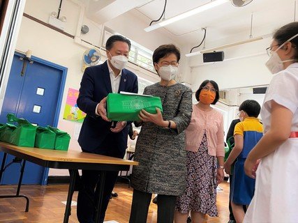 保良局主席陈正欣博士与行政长官派发本局的复课物资包给学生。