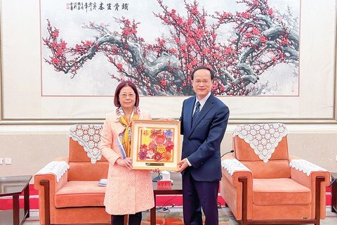 保良局癸卯年主席陳黎惠蓮女士代表董事會訪問團，致送由本局康復服務殘疾人士親手製作的摺紙花畫予中央統戰部三局彭嶺果副局長。