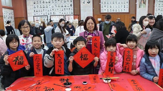 保良局陈黎惠莲主席(右四)和参与笔会的儿童手拿福字和挥春合照。