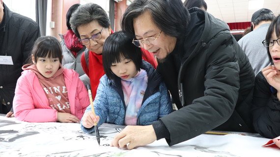 书画家带领保良局儿童写书法和绘画。