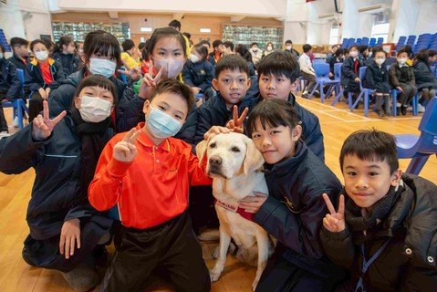 保良局黄永树小学学生在「退休导盲犬及长者嘉许礼」活动后与退休导盲犬合照。