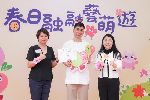 冯淑文专员（右一）及社会服务总干事(家庭及幼儿)梁李佩珊女士（左一）颁发得奖礼物及证书予「一同手作」吉祥物设计比赛的冠军陆敦龙先生（中）。