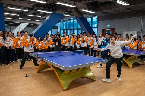 学生们与中国乒乓球奥运金牌得主丁宁切磋，从中学习技巧，现场气氛热烈。